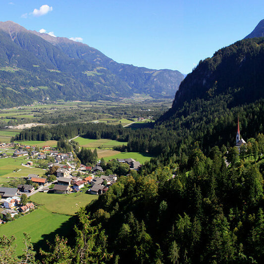 Luftaufnahme von Lavant im Sommer. Rechts im Bild zu sehen sind die Kirchen St. Ulrich und St. Paul.