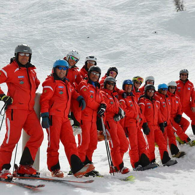 Team der Skischule White Element im Skizentrum Hochpustertal mit ihren auffälligen roten Skianzügen auf der Piste.