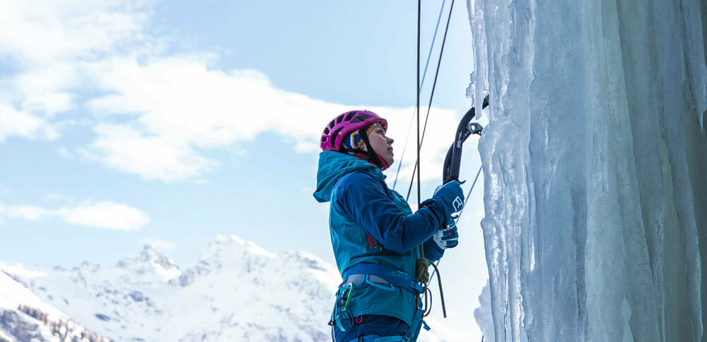 Eiskletterpark Osttirol Eine Person steht am Start einer abenteuerlichen Kletterroute über einen zugefrorenen Wasserfall.