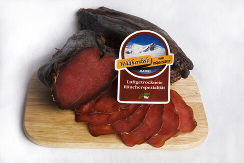 Wildhenkele von der Fleischhauerei Mühlstätter in Matrei auf einem Holzbrett. 