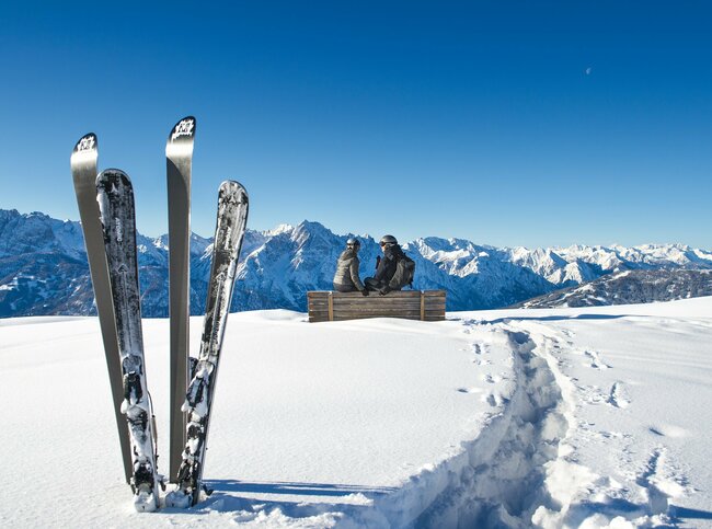 Skifahren am Zettersfeld - Ski stecken im Schnee mit Bergpanorama bei strahlend blauem Himmel