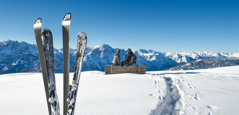 Skifahren am Zettersfeld - Ski stecken im Schnee mit Bergpanorama bei strahlend blauem Himmel