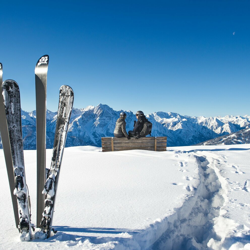 Skifahren am Zettersfeld - Ski stecken im Schnee mit Bergpanorama bei strahlend blauem Himmel