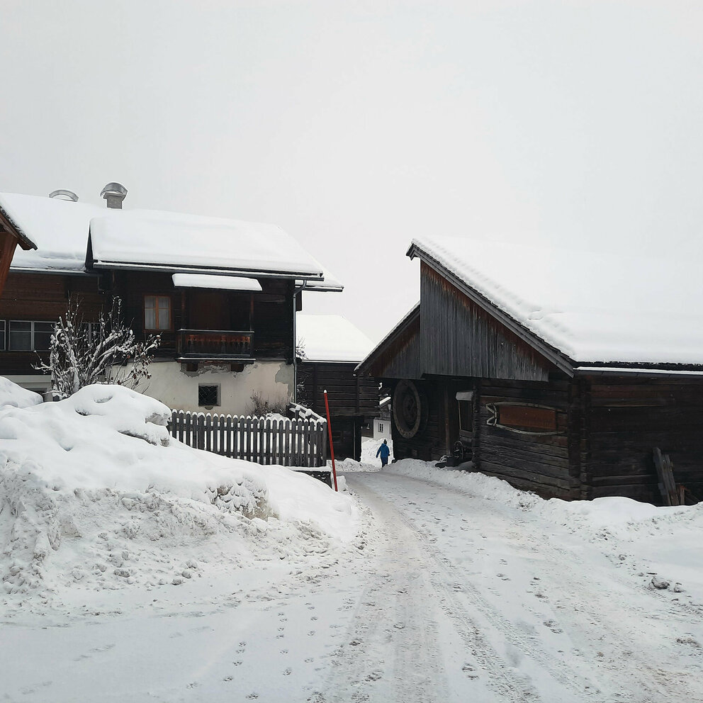 Neuschnee in Obertilliach - schneebedeckte Häuser und alte Heustadel gehüllt in frischen Neuschnee