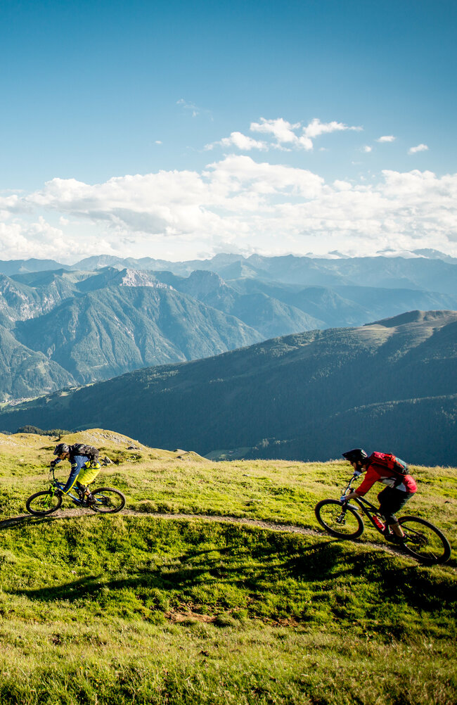 Radfahren mit einzigartigem Panorama Zwei Radfahrer auf einem schmalen Trail mit einzigartigem Bergpanorama.