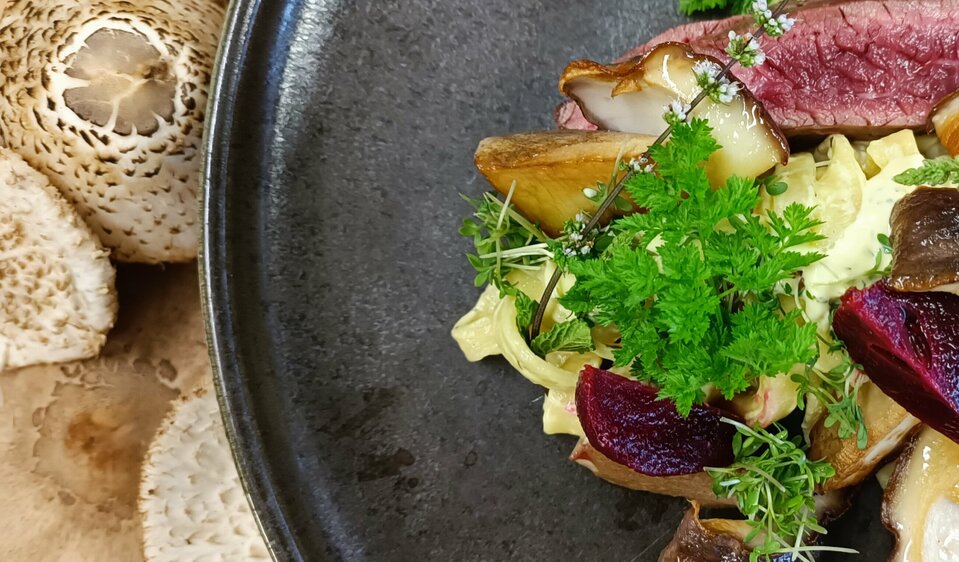 Schwarzer Teller mit Steak und Beilagen im Moarhof.