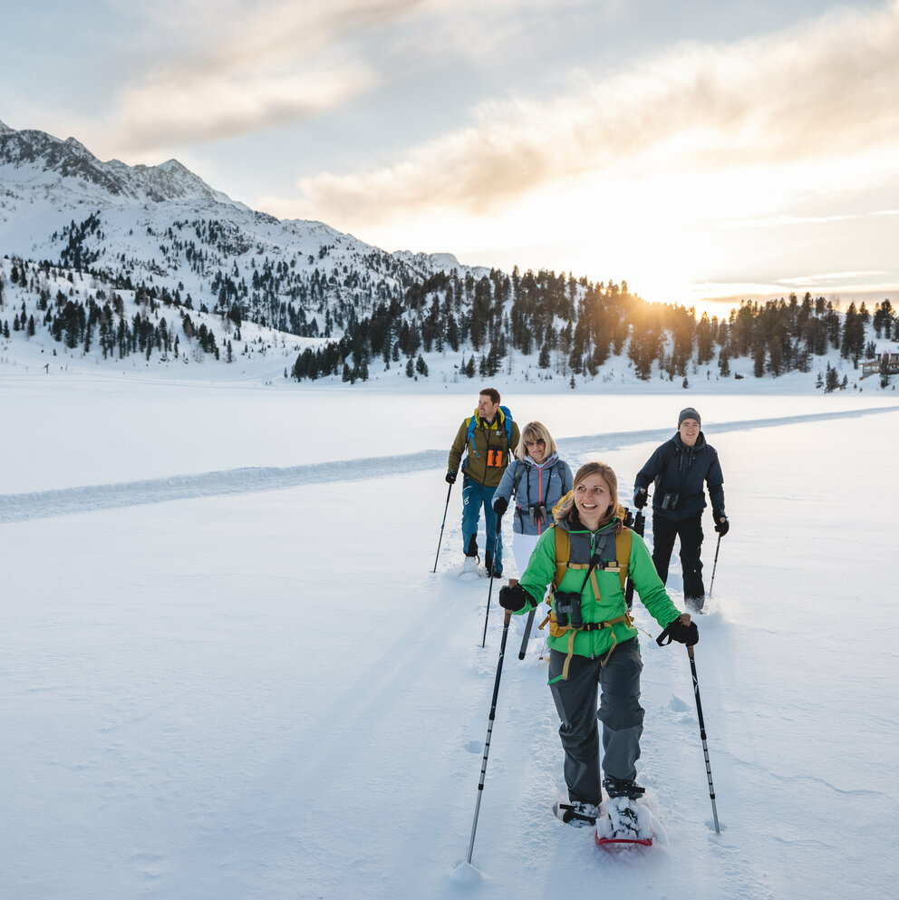 Eine Gruppe Schneeschuhwanderer:innen bei bewölktem Wetter im Nationalpark Hohe Tauern