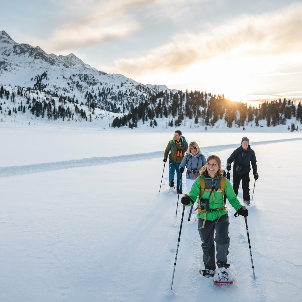 Eine Gruppe Schneeschuhwanderer:innen bei bewölktem Wetter im Nationalpark Hohe Tauern