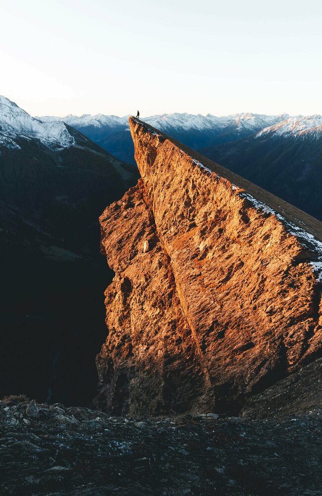 Bretterwand, also ein Berg, wird von der Sonne schön beleuchtet. Der erste Schnee ist schon gefallen und noch Schneereste liegen auf den umliegenden Berggipfeln.