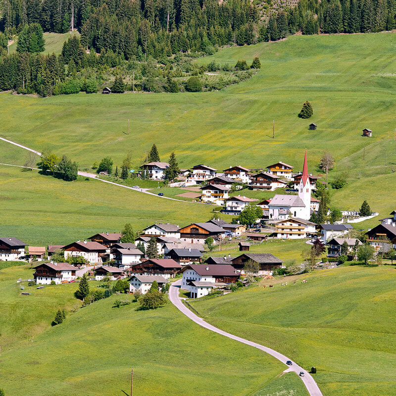 Luftaufnahme des Weilers Abfaltern der Gemeinde Abfaltersbach im Sommer. Grüne Wiesen umgeben den Weiler und oberhalb die ersten Bäume eines Waldes.