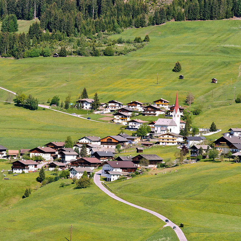 Luftaufnahme des Weilers Abfaltern der Gemeinde Abfaltersbach im Sommer. Grüne Wiesen umgeben den Weiler und oberhalb die ersten Bäume eines Waldes.