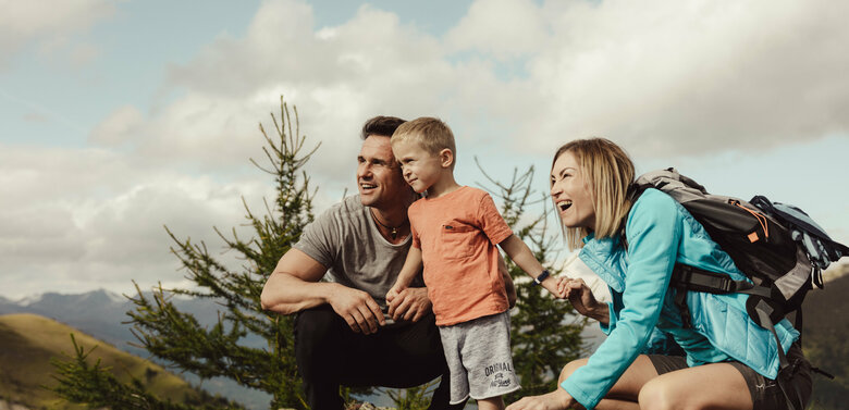 Eine junge Familie schaut gespannt in die Ferne auf der Kindermeile Obertilliach