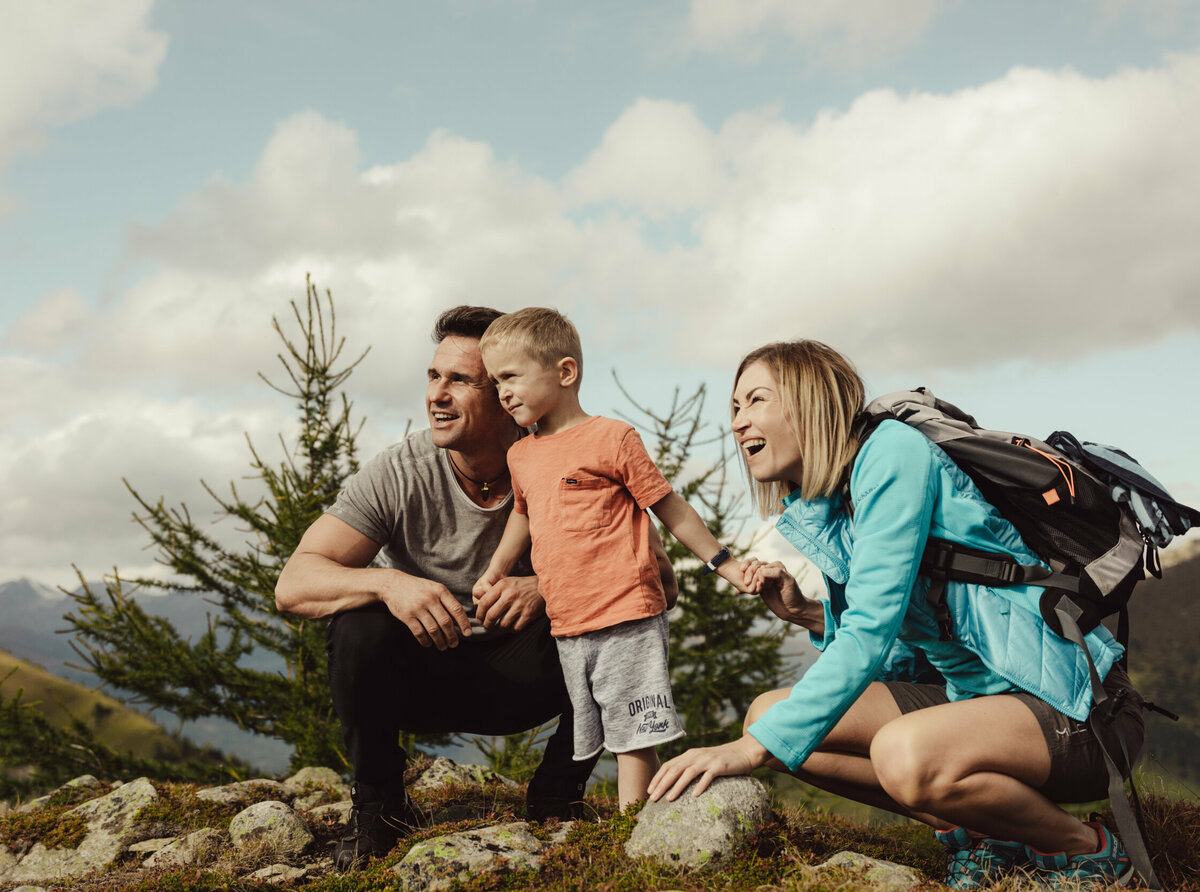 Eine junge Familie schaut gespannt in die Ferne auf der Kindermeile Obertilliach