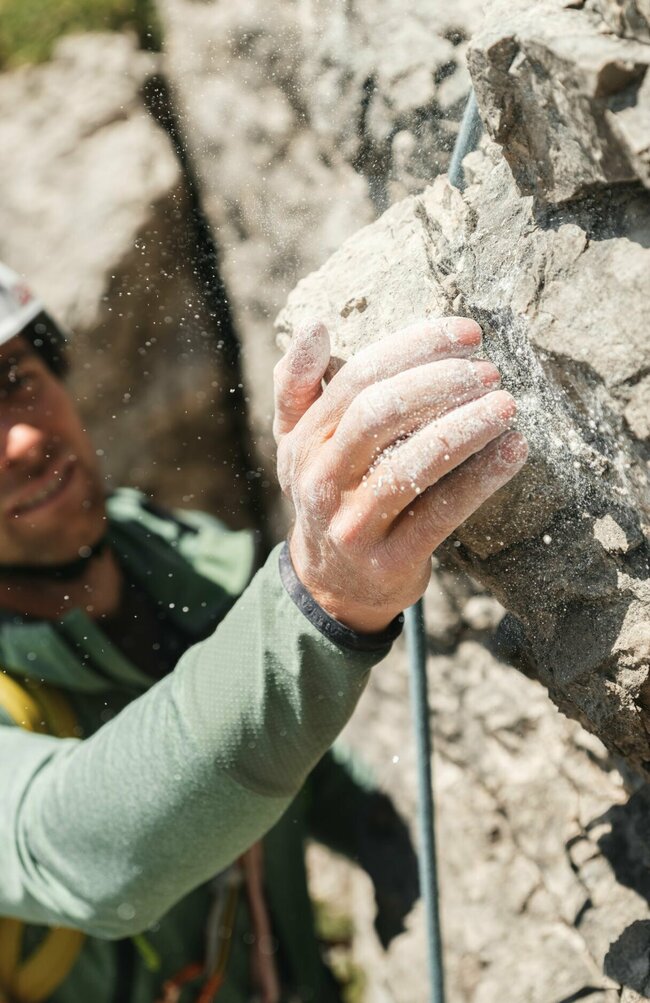 Magnesium Klettern Aufnahme von der Hand eines Kletterers mit Magnesium an einem Fels.