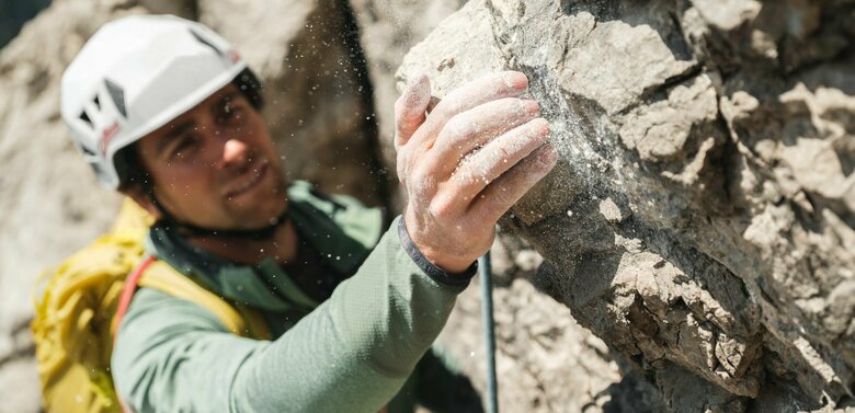 Aufnahme von der Hand eines Kletterers mit Magnesium an einem Fels.