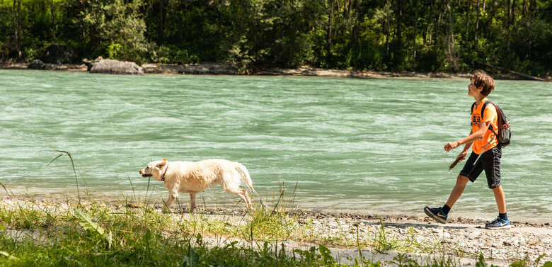 Kind wandert mit Hund am Iseltrail direkt neben der Isel.