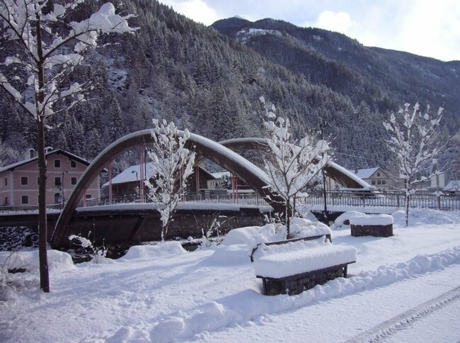 St. Johann Die Brücke in St. Johann mit viel Neuschnee und einem Wald im Hintergrund.