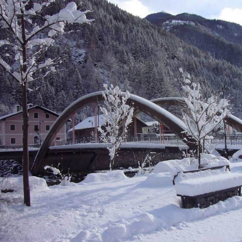 Die Brücke in St. Johann mit viel Neuschnee und einem Wald im Hintergrund.