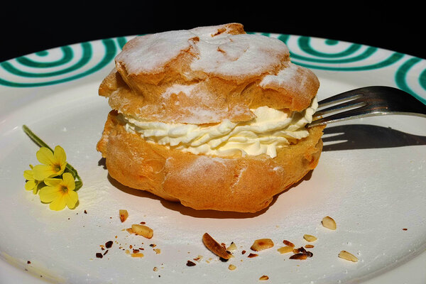 Teiggebäck Tauernwindbeutel auf einem Teller mit einer Gabel.