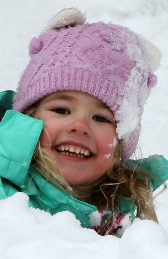 Ein Kind spielt fröhlich im frischen Schnee