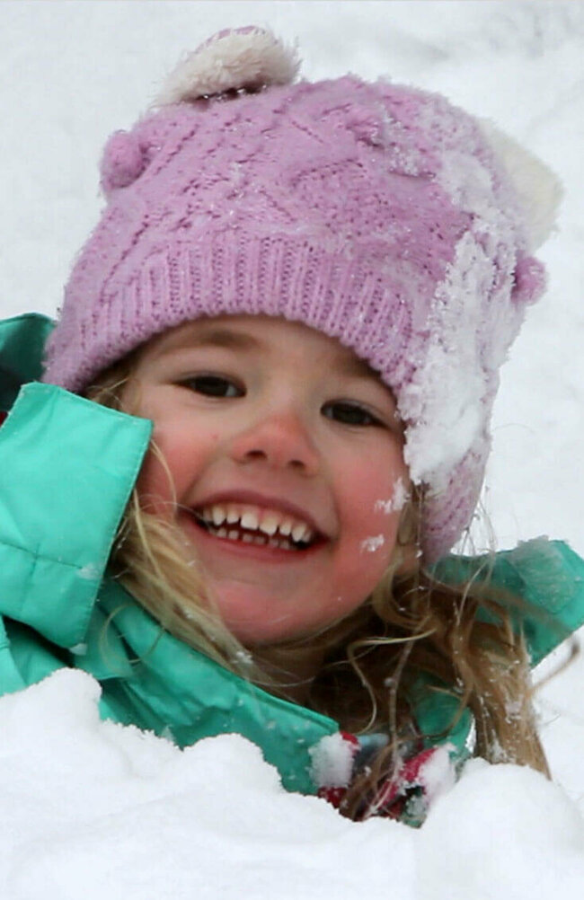 Ein Kind spielt fröhlich im frischen Schnee
