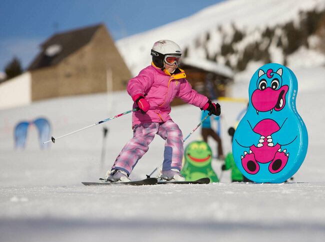 Kind fährt am Zettersfeld durch lustige Figuren