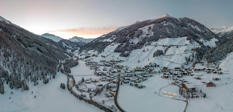Abendlicher Blick von oben auf das verschneite Dorf St. Jakob im Defereggen im Winter.