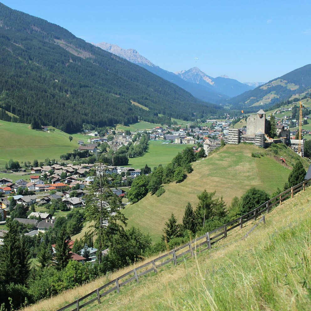 Heinfels Luftaufnahme vom Dorf Heinfels, umringt von den Bergketten der Region unter wolkenlosem Himmel im Sommer.