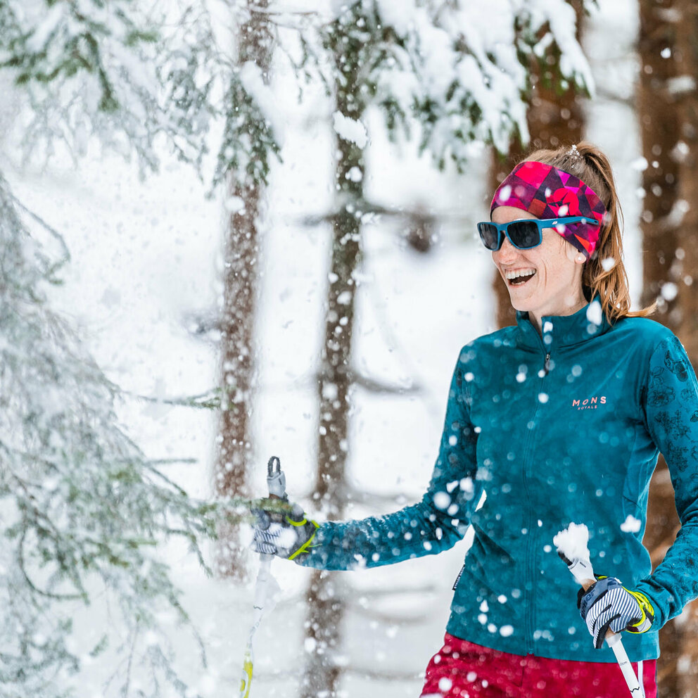 Portrait einer Frau beim Langlaufen in Obertilliach im frisch verschneitem Wald.