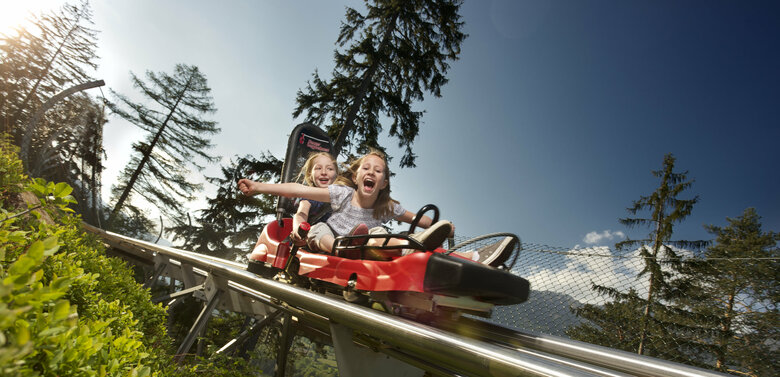 Zwei Mädchen genießen die spektakuläre Abfahrt mit dem Osttirodler vom Hochstein