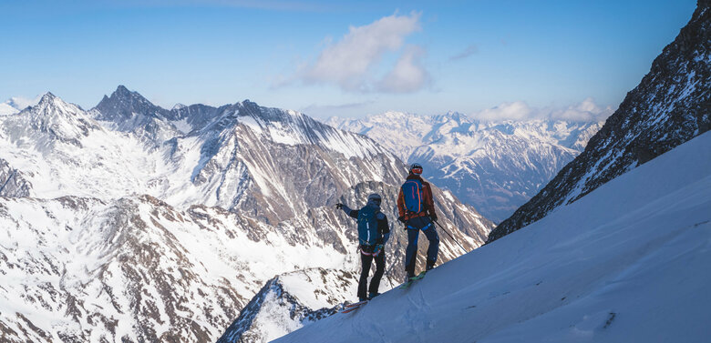 Hoch Tirol plus Ausblick Regentörl Zwei Skitourengeher:innen genießen den Ausblick aufs Regentörl und blicken in die verschneite Berglandschaft.