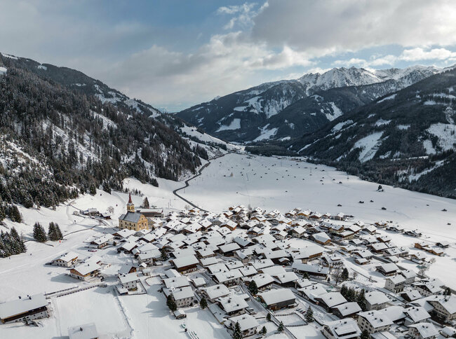 Drohnenaufnahme des verschneiten Obertilliachs aus westlicher Richtung auf das Dorf.