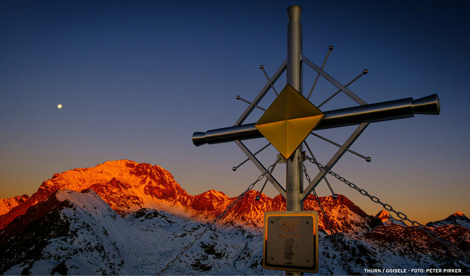 Ein Sonnenuntergang am verschneiten Berggipfel als buntes Naturspektakel in Thurn.