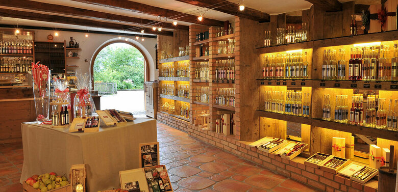 Innenansicht des Hofladens der Schnapsbrennerei Kuenz in Dölsach mit vielen verschiedenen Schnäpsen und Likören sowie Äpfel.
