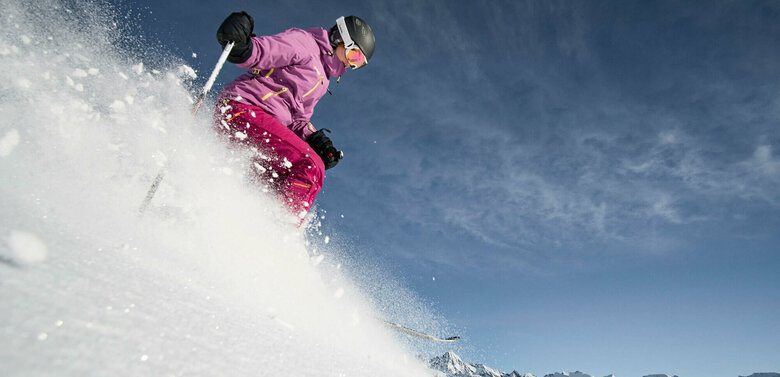 Freeriden Großglockner Resort Kals Matrei Eine pink-lila gekleidete Freeriderinn im Pulverschnee im Großglockner Resort in Kals-Matrei.