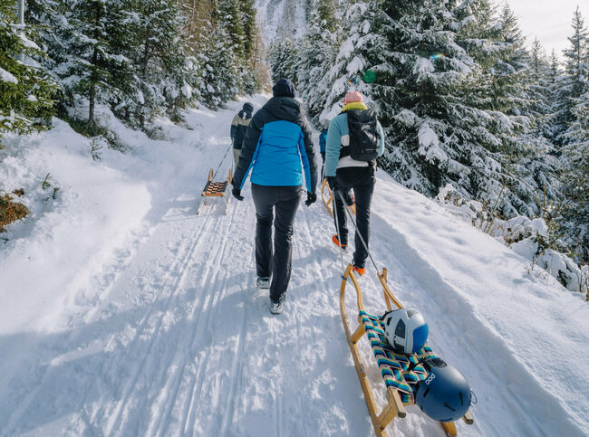 Eine Familie macht sich auf den Weg bergauf zum Startpunkt der Rodelbahn im Außervillgrater Winkeltal.