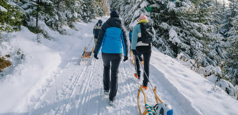Eine Familie macht sich auf den Weg bergauf zum Startpunkt der Rodelbahn im Außervillgrater Winkeltal.