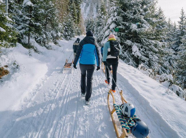 Eine Familie macht sich auf den Weg bergauf zum Startpunkt der Rodelbahn im Außervillgrater Winkeltal.