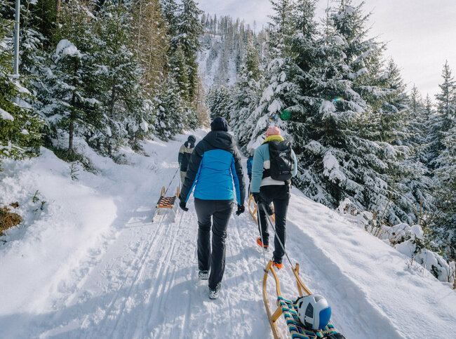 Eine Familie macht sich auf den Weg bergauf zum Startpunkt der Rodelbahn im Außervillgrater Winkeltal.