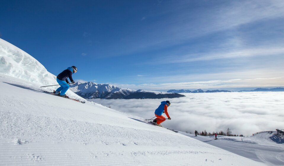 Skifahren Sillian Zwei Skifahrer:innen bei der Abfahrt im Skigebiet Sillian