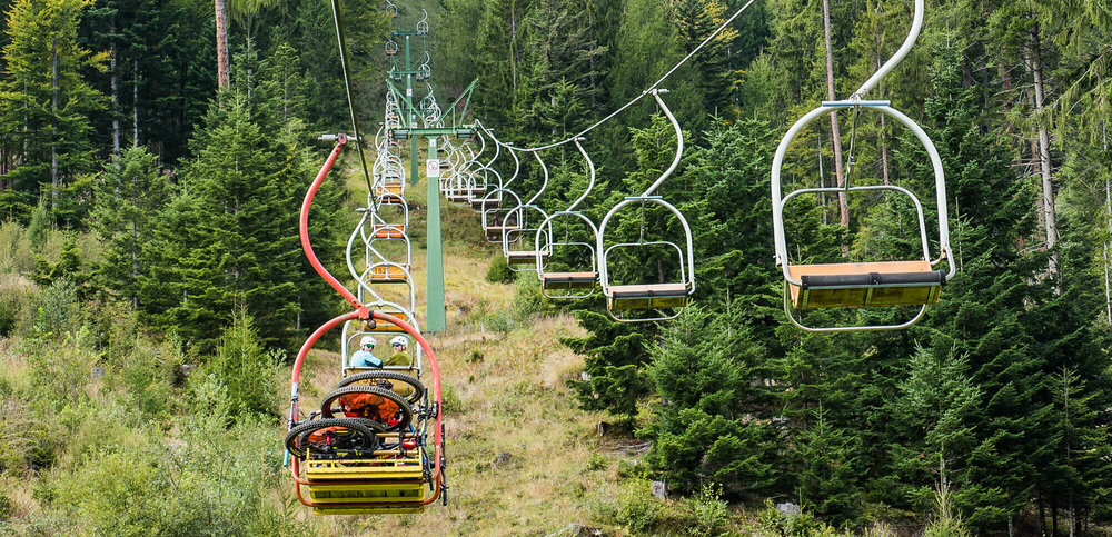 Lienzer Bergbahn Hochstein Sessellift Zwei Liftfahrer drehen sich während der Fahrt mit dem Sessellift der Lienzer Bergbahn Hochstein zur Kamera um.