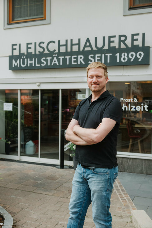 Ein Mann steht vor dem Eingang einer Fleischhauerei