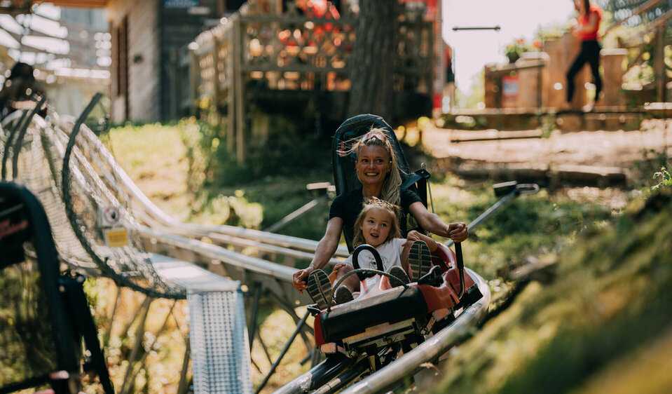 Ganzjahresrodelbahn Osttirodler am Hochstein Pista da slittino estiva “Osttirodler” con mamma e bambino.