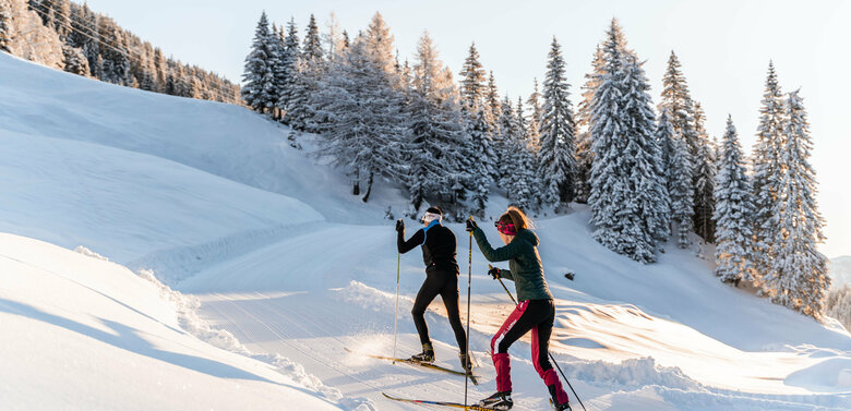 Langlaufen in Rauchenbach Zwei Langläufer:innen auf der Langlaufloipe in Kartitsch bergauf zur Höhenloipe und dem Dorfberg.