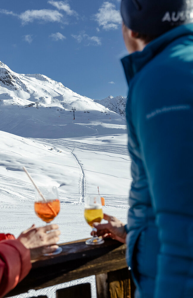 Skizentrum St. Jakob i. D. Skifahrer genießen ein Erfrischungsgetränk mit Blick auf die Pisten des Skizentrum St. Jakob i. D..