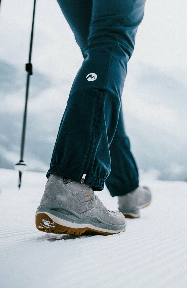 Zwei Personen sind beim Winterwandern auf perfekt präparierten Winterwanderwegen unterwegs.