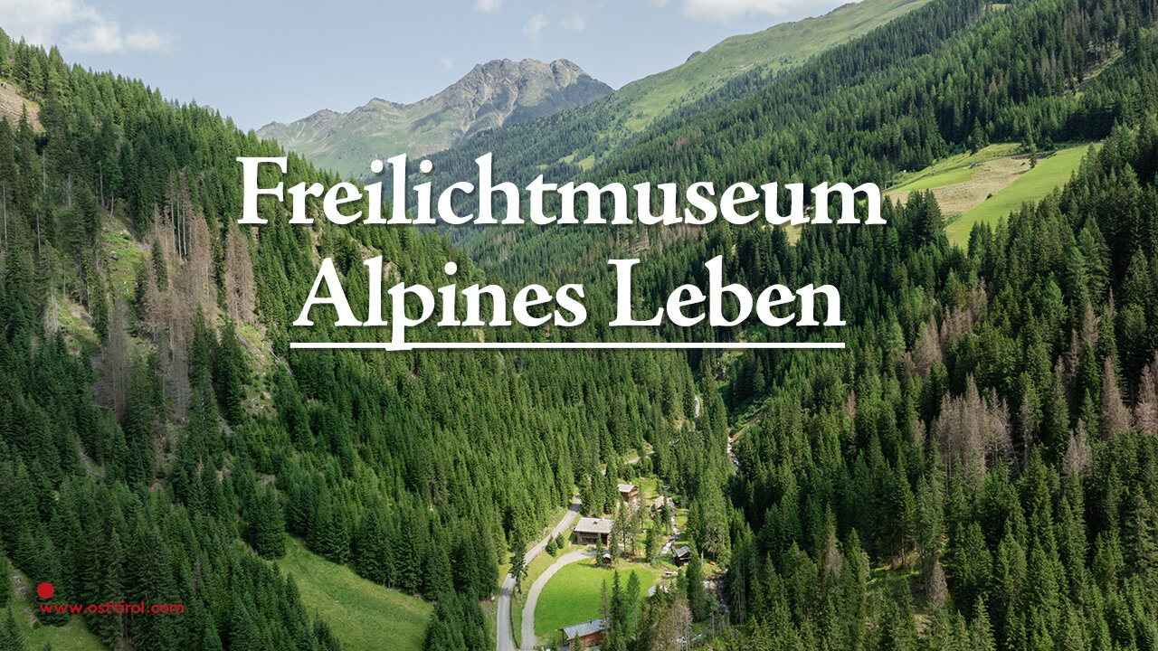 Werbebild für das Freilichtmuseum Alpines Leben mit Schriftzug auf einem Bild von einem bewaldeten Tal.