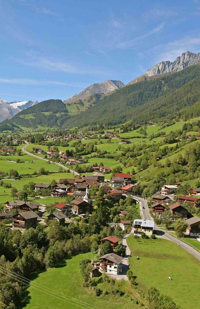 Die Gemeinde Virgen im Sommer umgeben von grünen Wiesen und Wäldern.